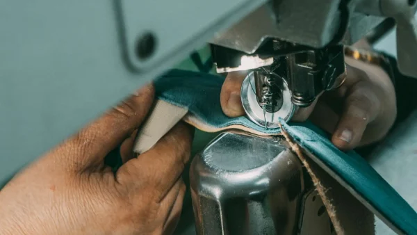 LG Shoes - Footwear size grading: how brands protect fit consistency across a size range 3 Close-up of a footwear specialist working on shoe upper construction during the manufacturing process.